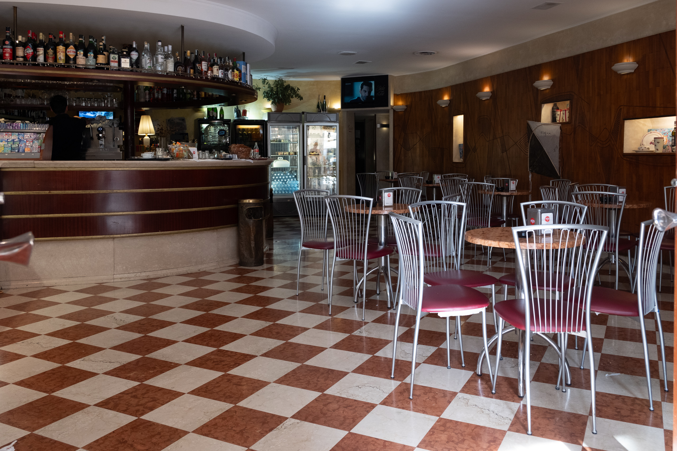 Klassische Bar – Schachbrettboden und rote Polsterstühle